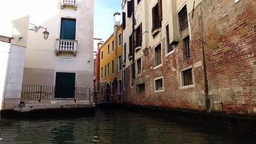 Sailing Gondola With A View Of Old Buildings With Brick Walls In Venice, Italy. POV