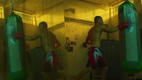 An athlete practices punches in a boxing gym with punching bags