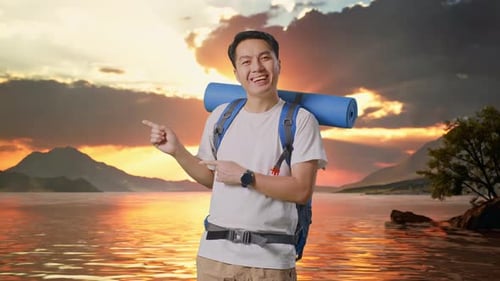 Asian Male Hiker Smiling And Pointing To Side At A Lake