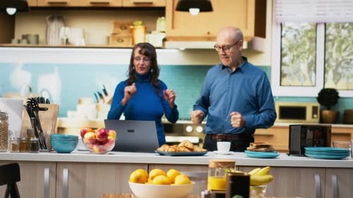 Cheerful Life Partners Enjoying a Funny Morning Dance in the Kitchen