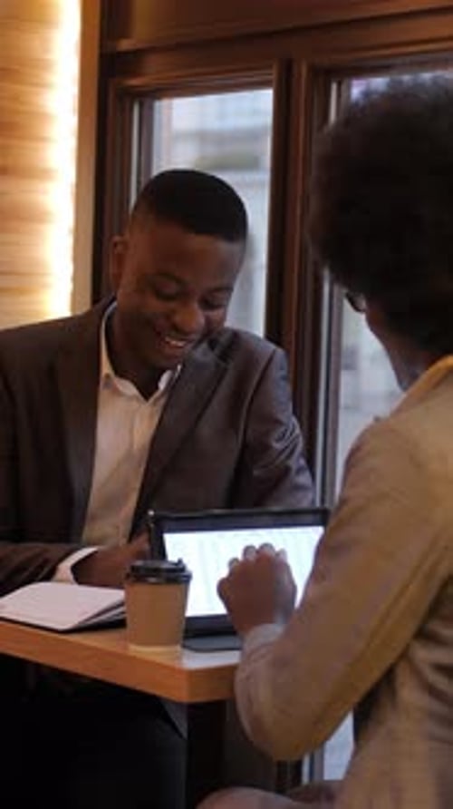 Business Partners Using Gadgets for Work at Cafe