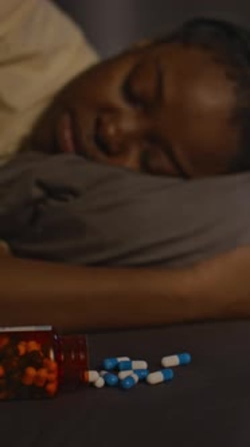 Woman Sleeping Near Medication Bottles at Night