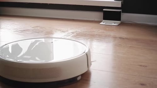 White Robot Vacuum Cleaner Returning to Charging Station