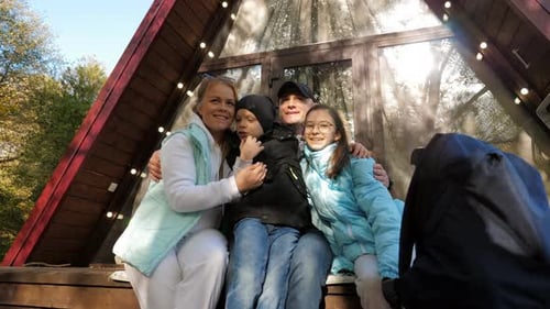 A Happy Family on the Threshold of a Forest House Hugging