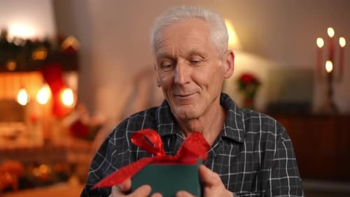 Smiling Senior Man with Christmas Gift Indoors