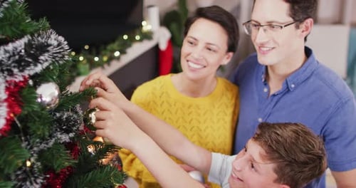 Happy Family Decorating the Christmas Tree Together