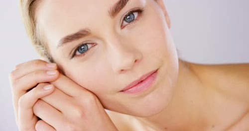 4k video footage of an alluring beautiful woman posing against a studio background