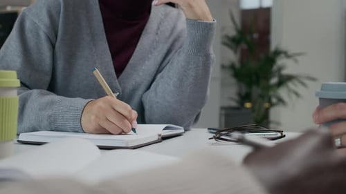 Büroangestellter schreibt Notizen während der Teambesprechung im modernen Konferenzraum