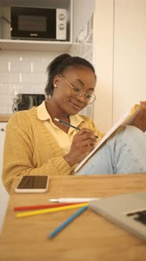 Young Woman Working at Table in Kitchen