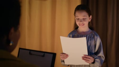 Cheerful Girl Reading Script On Stage