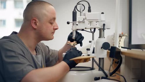 Man Working with Artificial Teeth in Dental Lab