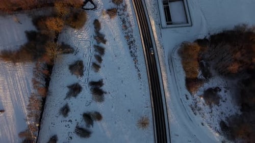 Traffic on interstate road of American town during snowy winter day in America. Aerial top down