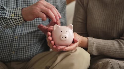 Saving Money Investment for Future Senior Adult Mature Couple Hands Holding Piggy Bank Putting Money