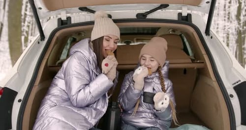 Mother and Daughter Sitting in a Car Truck in Winter Forest