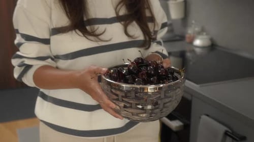 Woman Carries Bowl of Cherries to Table