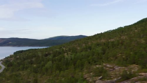 Drone Approaching Lake Amidst Mountainous Landscape