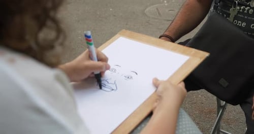Girl drawing face of a man in the park