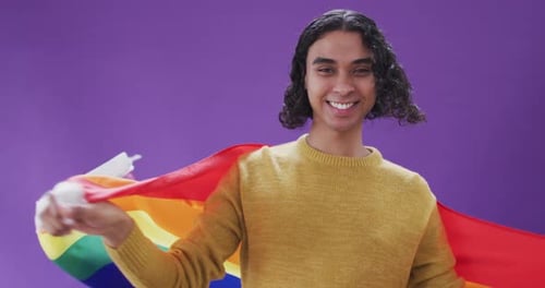Person Smiling and Holding Pride Flag