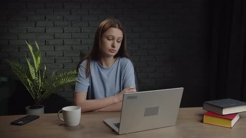 A Tired Woman Sits at a Table with a Laptop and Discusses a Study Project with Classmates Video with
