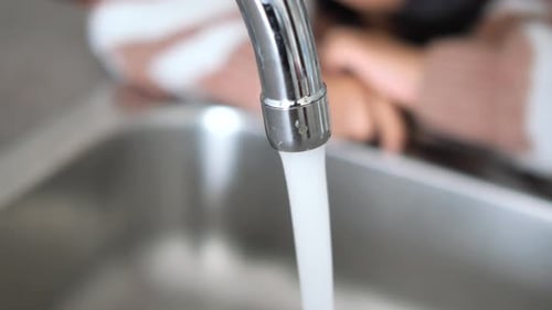Shiny Faucet Water Flowing in Silver Sink