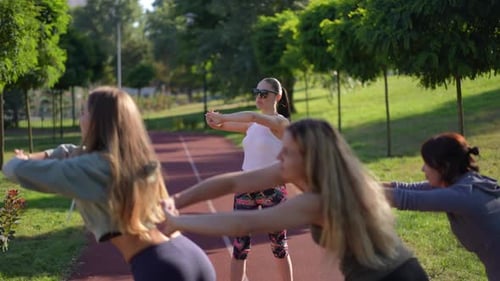 Women Exercising and Stretching Together in Grassy Park