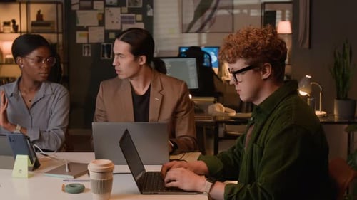 Multiethnic Software Developers Working on Laptops in Office