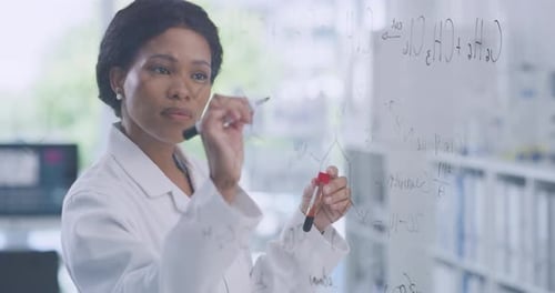 Des scientifiques écrivent sur un tableau d'aide visuelle clair, enregistrant les modifications des composés chimiques