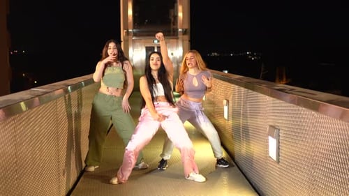 Dançarinos alternativos de hip hop dançam em uma ponte à noite