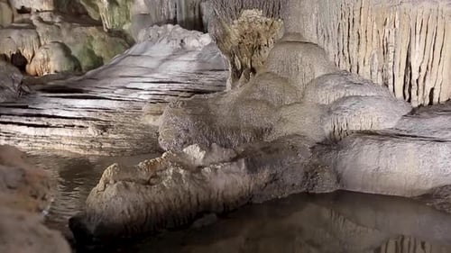 Giant limestone underground cave with pure white stalactites and stalagmites. Waterfalls inside the