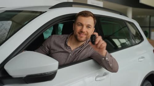 Happy Customer Showing Car Keys in Dealership