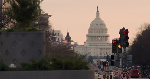 Traffic Signal Arrows Turning Red To Green In Front Of U.S. Capitol Building With Orange Sky