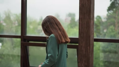 Pensive Businesswoman Walks Along Glass Terrace