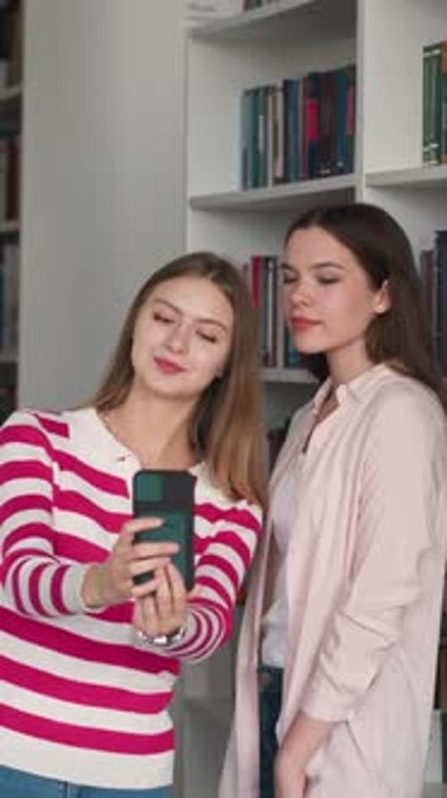 Young Women Using Phone in Library