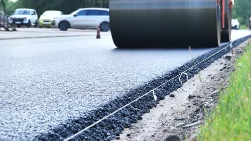 Road Roller Compacting Fresh Asphalt on a New Road Construction Site