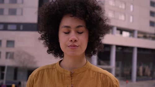 Young Beautiful African American Girl Serious Looking at Camera and Afro Hair People Outdoors