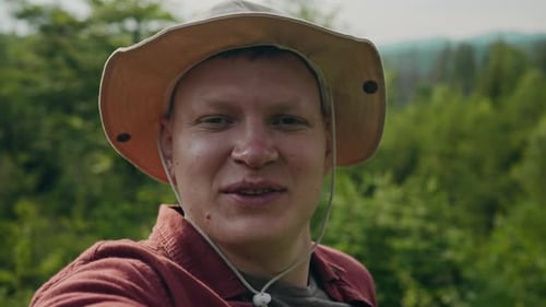 Young Adult Talking in Front of Green Forest