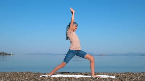 Mädchen praktizieren Warrior Yoga an Land