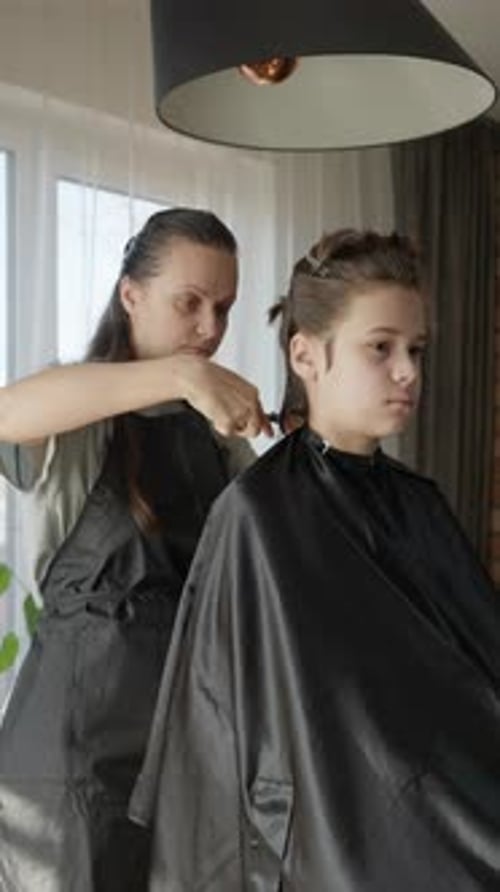 Una peluquera que trabaja desde casa, le hace un corte de pelo profesional a un niño