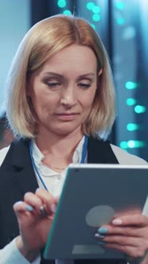 A Professional Woman Utilizing a Tablet in a Contemporary Office Setting for Various Tasks