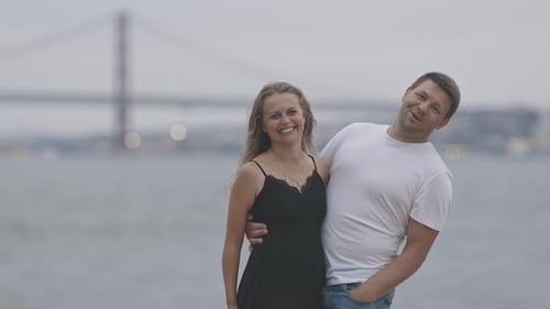A Cute Married Couple Standing on the Pier in Cloudy Weather