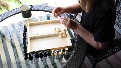 Woman Plays Chess on a Sunny Terrace
