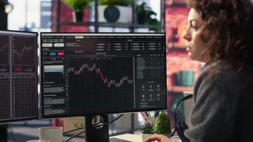 Businesswoman Studies Financial Charts Using Stock Market Visualization Tools