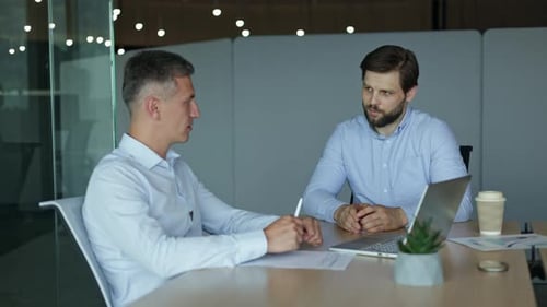 Men Talking at Table in Modern Office
