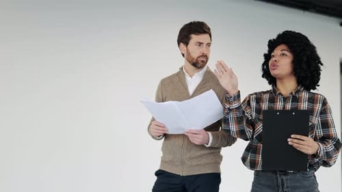 Business Meeting Colleagues Discuss Blueprints in a New Office Space