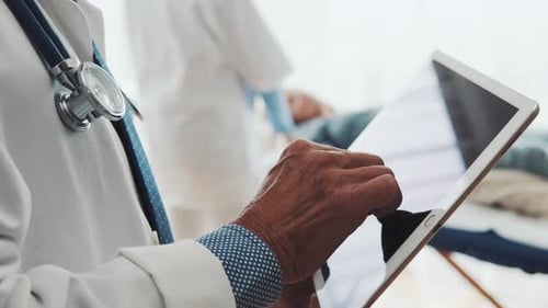 Senior Doctor Using Tablet in His Office