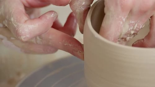 Potter's Hands Shaping Clay on a Spinning Wheel