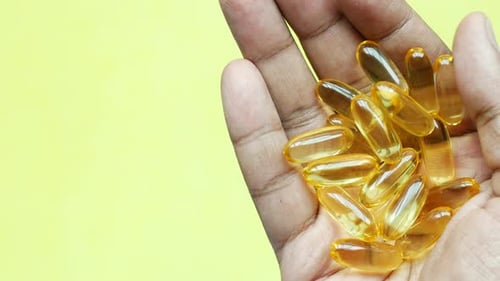 Fish Oil Supplement on Hand Top View