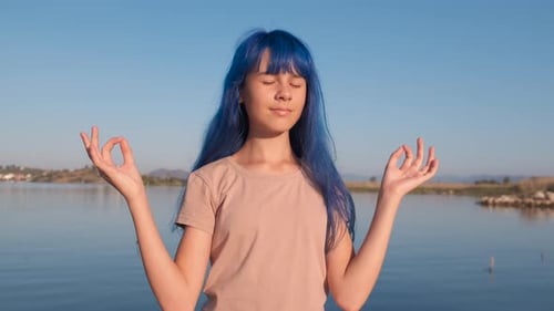 Young Woman Meditating by a Peaceful Lake
