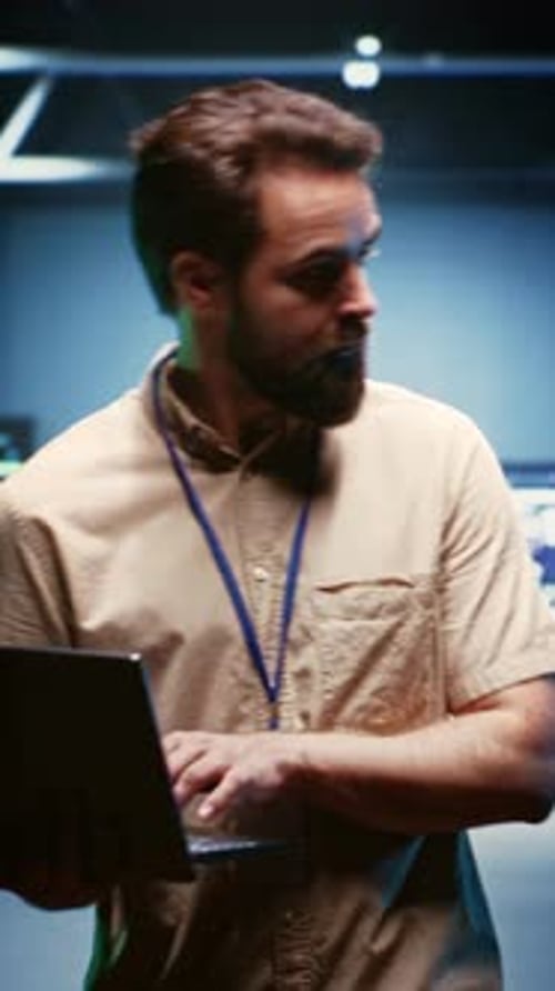 Bearded Man Working on Laptop in Server Room