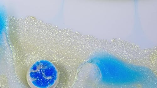 Blue Liquid with Shimmering White Glitter and Bubbles